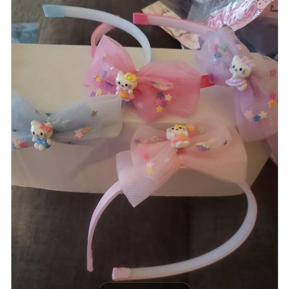 Four Hello Kitty headbands with small figurine